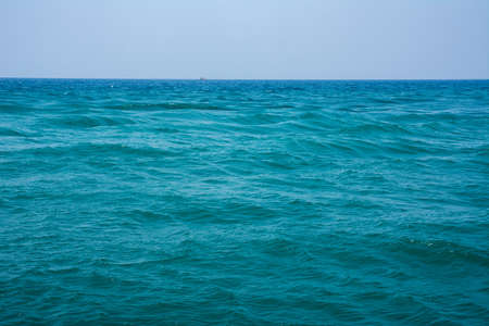 Beautiful sea with turquoise colored waves. Sea waves in the open sea, a boat can be seen on the horizon.の写真素材