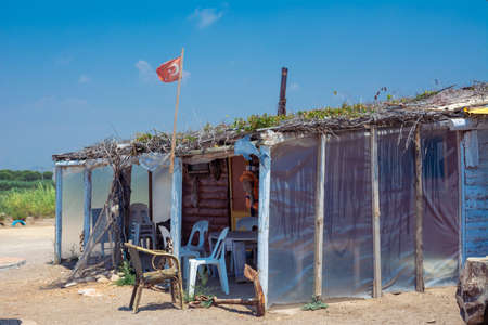 An old beach cafe with wooden houses painted white. Vintage Turkish cafe on the sea sandy beach.の写真素材