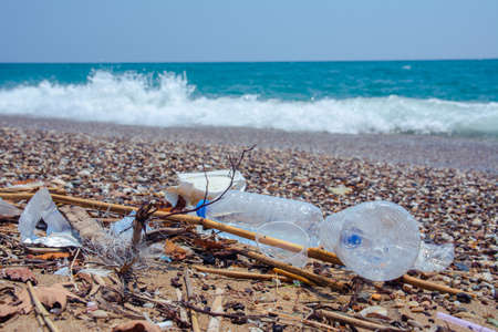 Garbage on the sea beach. A man-made garbage in the sea: plastic bottles, glasses and other plastic....