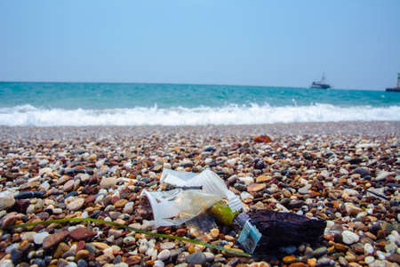 Garbage on the sea beach. A man-made garbage in the sea: plastic bottles, glasses and other plastic....