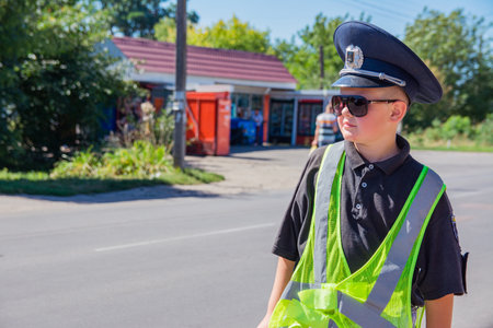 Pyryatyn, Ukraine 08.28.2020: a boy dressed as a police officer plays as a traffic control officer....