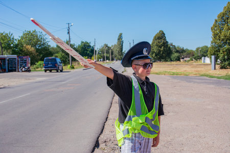 Pyryatyn, Ukraine 08.28.2020: a boy dressed as a police officer plays as a traffic control officer....