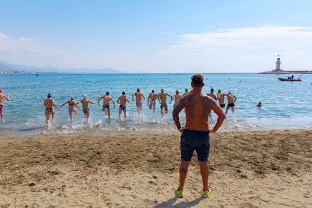 Alanya, Turkey, 10/16/2022: The coach trains the triathlon team on the sea beach. A team of athletes is preparing to swim in a swimming competition. Athletes are preparing to swim in the sea.のeditorial素材