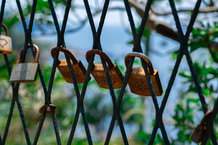A mesh fence on the seashore with padlocks symbolizing love. Love locks are hung on the fence in large numbers on the sea promenade. sea background.の写真素材