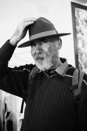 Bearded Old Man in a Hat. An old traveler with a backpack and a beautiful hat. Black and White Portrait of a Handsome Old Man.の写真素材
