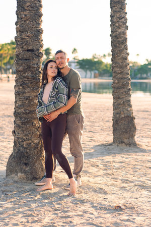 A couple in love hugs on the sea beach. A man and a woman enjoy each other and their vacation by the sea.の写真素材