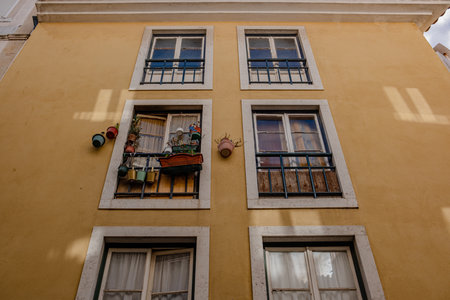 Street of Lisbon city. Washed clothes hang from the balcony and dry outside. Clothes dry on the balcony, old vintage houses, authentic architecture.の写真素材