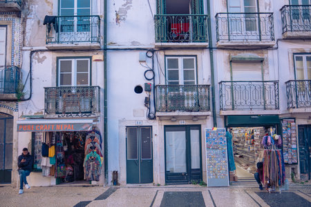Street of Lisbon city. Washed clothes hang from the balcony and dry outside. Clothes dry on the balcony, old vintage houses, authentic architecture.の写真素材