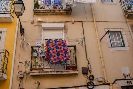 Street of Lisbon city. Washed clothes hang from the balcony and dry outside. Clothes dry on the balcony, old vintage houses, authentic architecture.の写真素材