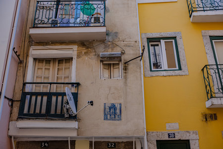 Street of Lisbon city. Washed clothes hang from the balcony and dry outside. Clothes dry on the balcony, old vintage houses, authentic architecture.の写真素材