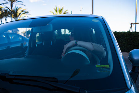 A girl driving a modern car in the south of Spain. View of the driver's girlfriend through the...