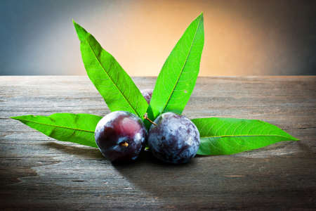 plum and leaf on wood の写真素材