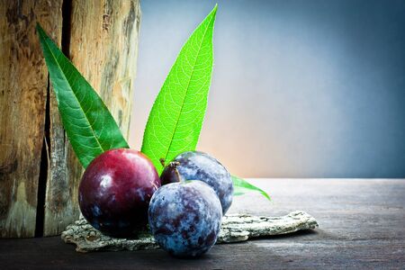plum and leaf on wood の写真素材