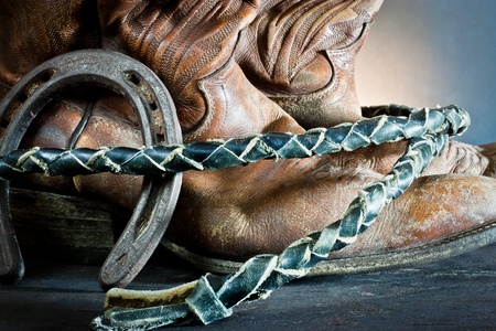 Cowboy boots,horseshoe and whip on wood の写真素材
