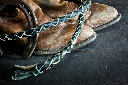 Cowboy boots,horseshoe and whip on wood の写真素材