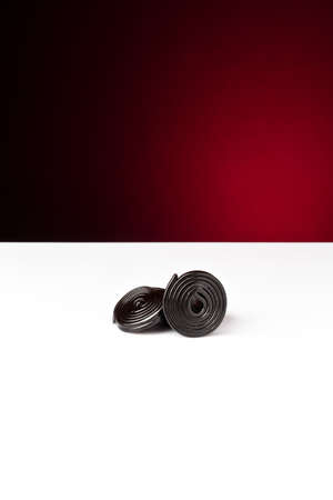 rolls of liquorice on  white and red backgroundの写真素材