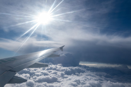Airplane wing and sunbeams through the cloudsの写真素材