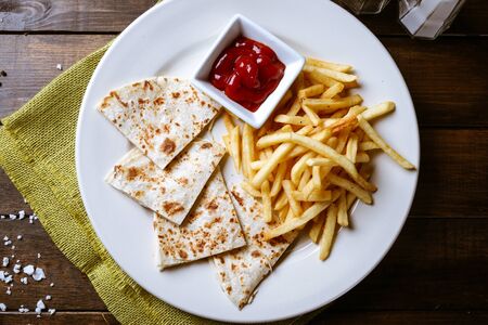Chicken quesadillas with french fries and ketchup