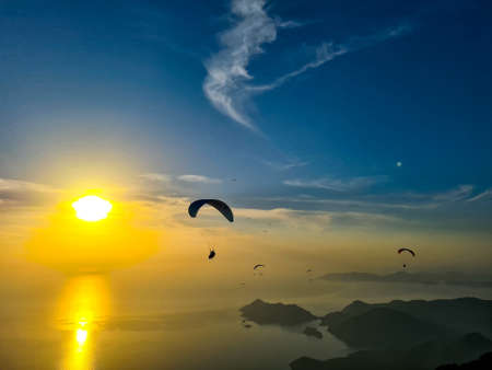 Beautiful view of golden hour sunset with paragliders