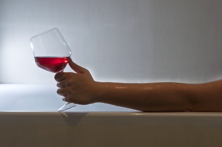 Woman taking a bath and relaxing with a glass of wineの写真素材