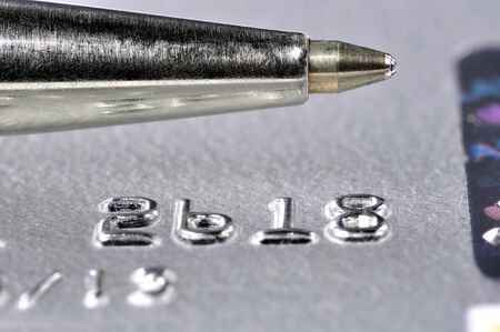 Closeup of a credit card with a silver pen on top of itの写真素材