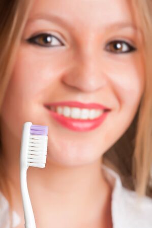 Closeup of young woman with a tooth brush on her hands, about to brush her teethの写真素材
