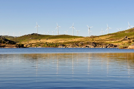Wind mill, with several wind turbines, near a river, producing green energy.の写真素材