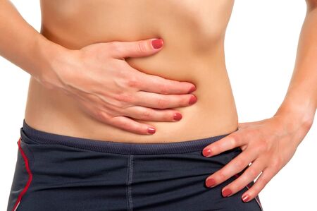 Woman suffering from stomach pain, isolated in white.の写真素材
