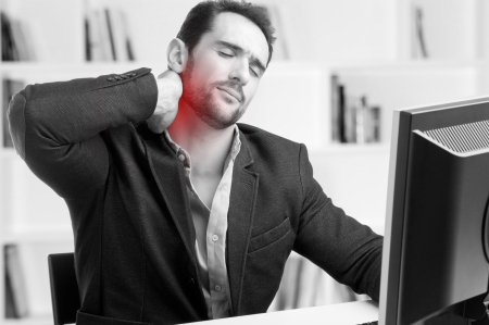 Casual businessman sitting in a desk with pain in his neck, black and white, red dot around painful areaの写真素材