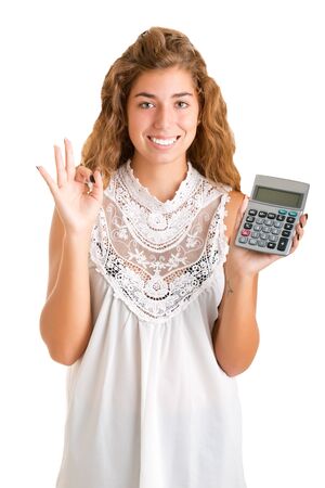 Happy woman holding a calculator in a white backgroundの写真素材