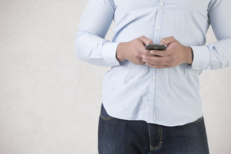 Young man using a smartphone to send a text messageの写真素材