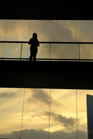 woman in the modern buildind at sunsetの写真素材