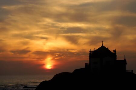 small church silhouette in the beach at sunsetの写真素材