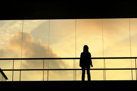 woman in the modern buildind at sunsetの写真素材