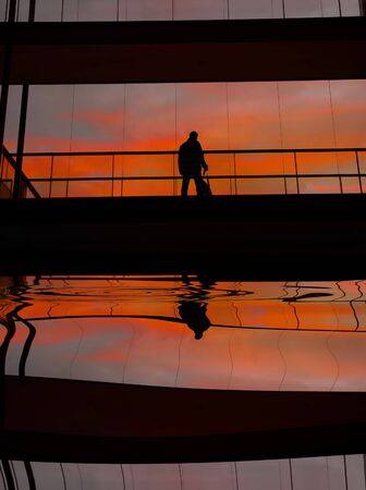 business man in the modern buildind at sunsetの写真素材