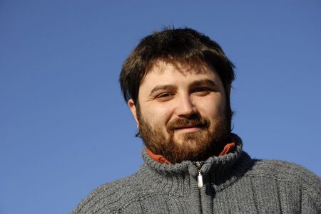 young casual man with the sky as background