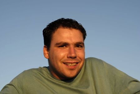 silly face young man with sky as backgroundの写真素材