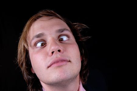 crazy young man portrait isolated on blackの写真素材