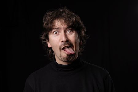 crazy young man portrait isolated on blackの写真素材