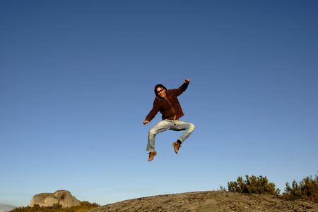 young man jumps high in the mountainの写真素材