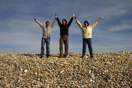 three casual young men at the beachの写真素材