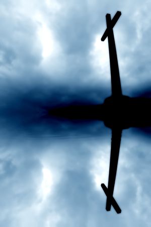 cross silhouette and the clouds with water reflectionの写真素材