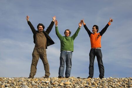 three casual young men at the beachの写真素材