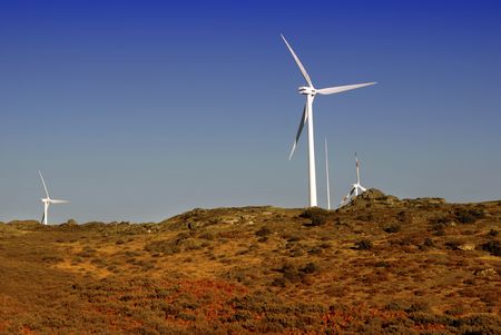 white wind turbine in the top of the mountain