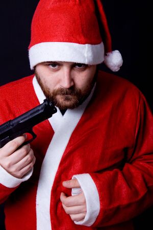 young man dressed as santa with a gunの写真素材