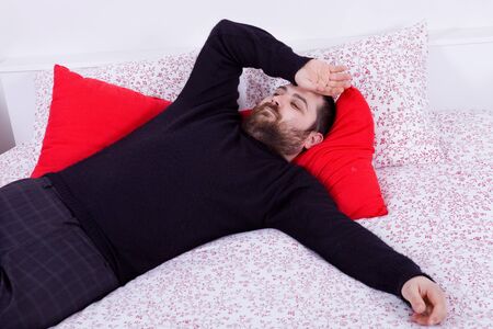 young casual happy silly man in bedの写真素材