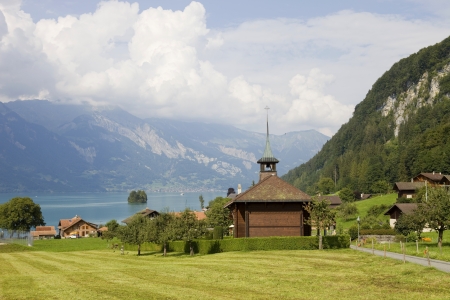View of wooden church with a lake and mountain at switzerlandの写真素材