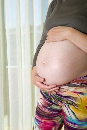 Closeup of pregnant woman at homeの写真素材