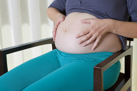 Closeup of pregnant woman at homeの写真素材