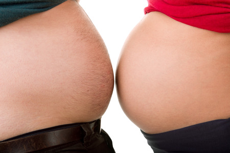 Pregnant woman with her husband, close up on the bellyの写真素材
